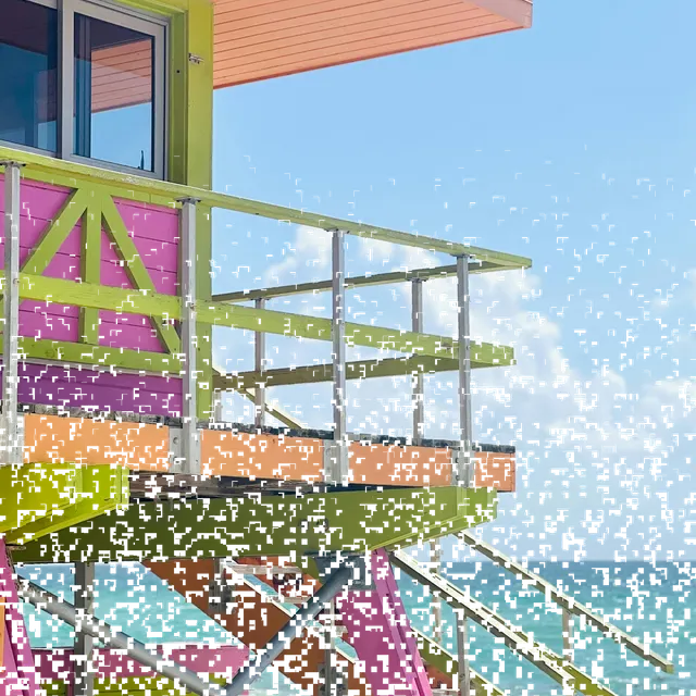 A pastel beach tower broken into square cells, some drifting down and fading out of the grid.